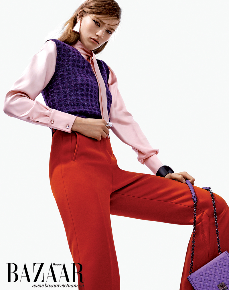 Áo len dệt kim, áo sơ-mi hồng, quần dài và túi xách, Bottega Veneta. Hoa tai, J.W. Anderson. Nhẫn, Eddie Borgo. Vòng tay, Narciso Rodriguez.