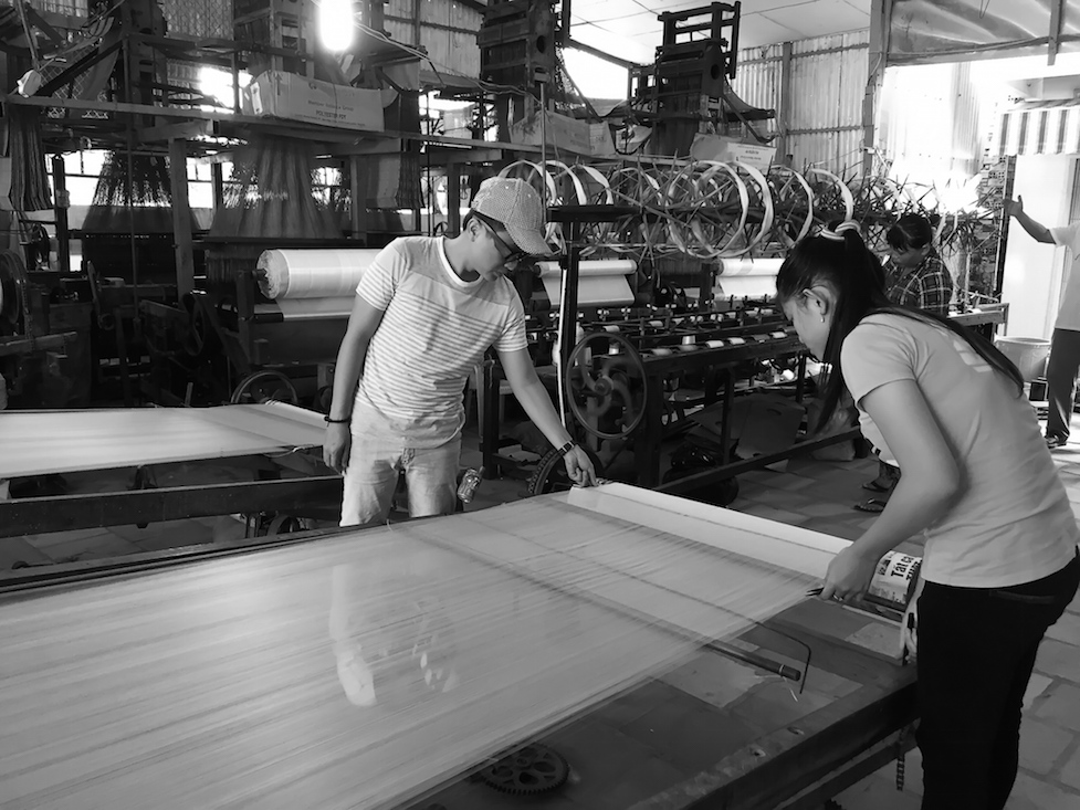 Nhà thiết kế bên khung dệt lụa.