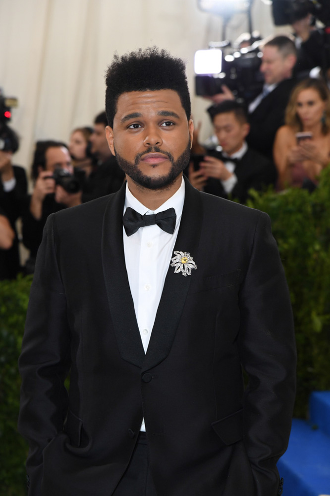 The Weeknd trong bộ suit của Valentino cùng Trâm cài bạch kim Cartier vintage (1962, nạm đá saphia 12.49 carat và kim cương), khuy rời đinh tán Cartier vintage (1925, vàng 18k nạm kim cương) và nhẫn gốm Cartier Maillon Panthère (vàng trắng 18k, nạm kim cương)