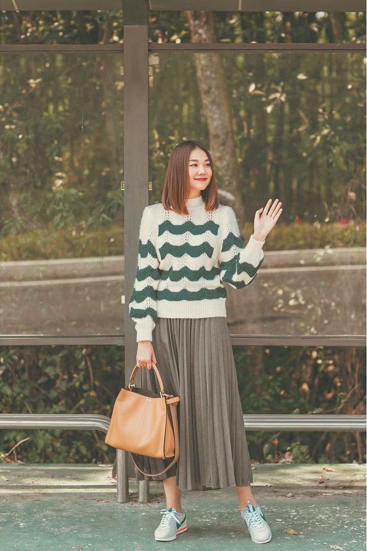 Thanh Hằng kết hợp áo len màu xanh trắng với váy màu xám